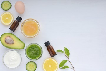 Natural skin remedy, ingredients for homemade cosmetics, honey, avocado, lemon, essential oil, cucumber, yogurt, egg, top view on white background, copy space.