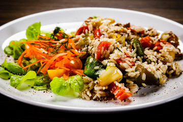 Grilled meat, white rice and vegetables on wooden table