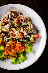 Grilled meat, white rice and vegetables on wooden table