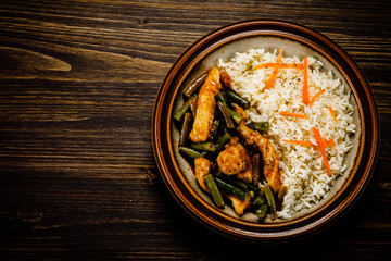 Grilled meat, white rice and vegetables on wooden table