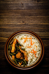 Grilled meat, white rice and vegetables on wooden table