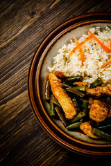 Grilled meat, white rice and vegetables on wooden table