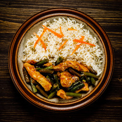 Grilled meat, white rice and vegetables on wooden table