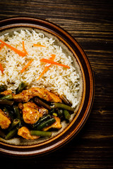 Grilled meat, white rice and vegetables on wooden table