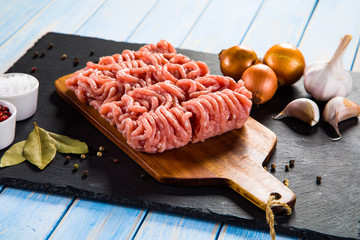 Raw minced pork on cutting board and vegetables