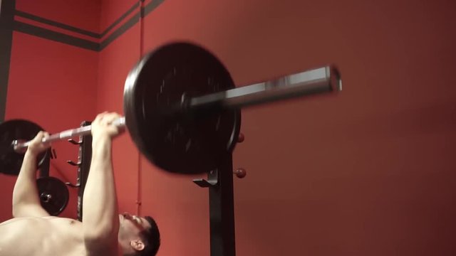Young man doing exercise bench-press. Closeup shot.