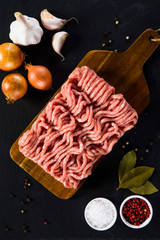 Raw minced pork on cutting board and vegetables