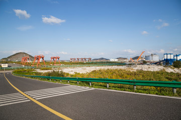 Off the coast of port, a large industrial equipment and oil storage tanks