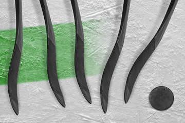 Five hockey sticks, puck and green stripe