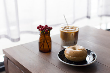 Fresh Bagel with coffee over wooden table.
