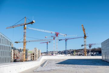 Construction building with cranes and derrick in the city