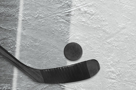 Hockey stick, puck and fragment of the ice arena with black and gray lines