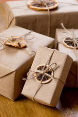 craft presents decorated with dry citrus on wooden background