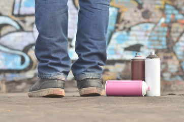 A still-life of several used paint cans of different colors agai