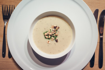 Sunchoke soup with roasted peanuts in white bowl