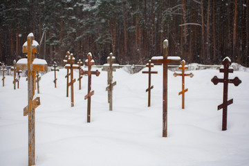 Wooden crosses covered with snow. Old Christian cemetery in winter