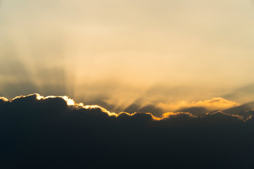 Thailand evening sunset in the deep sea of clouds depicts the last light of the bright orange and gold sun ray; a reflection of its beautiful, rare scenic, and romantic view over the sky at dusk.