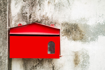 Red mailbox next to the wall