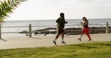 Side view of couple jogging at promenade on a sunny day 4k - Powered by Adobe