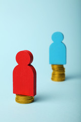 Gender inequality in level of pay concept. Coins on scales and people figures.