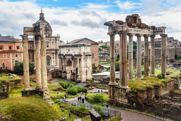 Fototapeta na wymiar Ruins of Roman Forum. Temple of Saturn, Temple of Vespasian and Titus, Arch of Septimius Severus and others. Rome. Italy