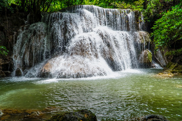Waterfall with tons of cold water on the mountain flowing beautifully at the tier 3 in the green jungle of Huay Maekamin National Park in Kanchanaburi province, Thailand, Asia