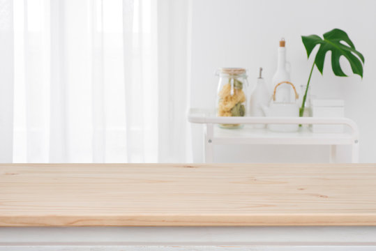 Blurred kitchen window, shelves background with wooden tabletop in front