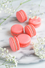Obraz na płótnie Canvas Coral cakes macarons or macaroons on white marble. The concept of Valentines day and spring's celebrating.