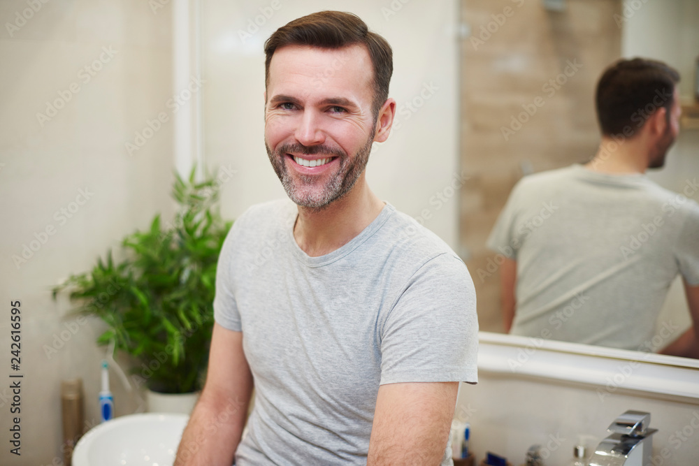 Wall mural Portrait of smiling man in the bathroom