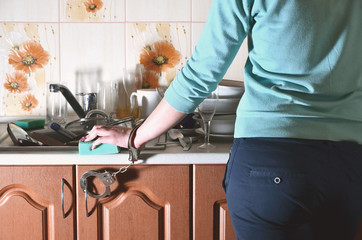 Fragment of the female body, handcuffed to the kitchen counter,