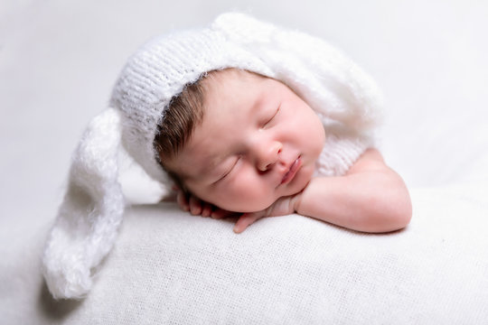 Portrait eines friedlich schlafenden, neugeborenen Babys auf einer weißen Decke