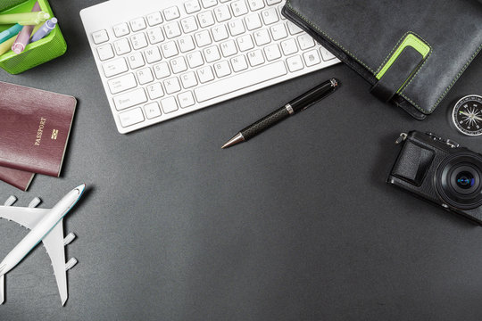 Travelling planning and business travelling trip concept. Accessories on desk table. Pc keyboard, passport, notebook, compass and airplane model. Top view with copy space