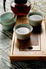 tea kettle with cups on a Chaban tea Board on a grey background