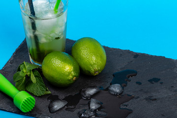 Bicchiere di mojto su piatto di ardesia con sfondo blù