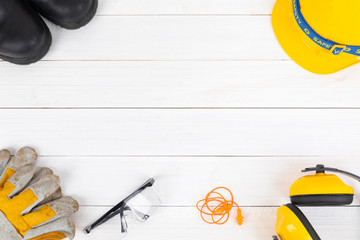 Banner image of construction safety equipment flat lay on white wooden.