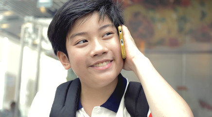 Happy Asian boy talking with cell phone with smile face.