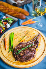 beef steak with salad, bread and wine on the table