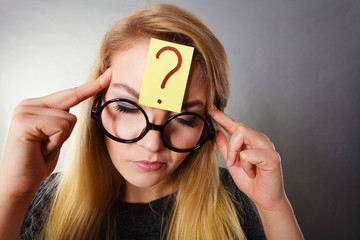 Woman having question mark on forehead thinking