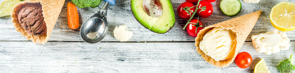 Trendy vegan food, summer healthy dessert concept, colorful diet vegetable ice cream with avocado, cucumber, tomato, beet, carrot, broccoli, cauliflower. Frozen veggie smoothie, wooden background