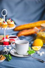 picnic. green tea in a teapot. tea in a cup. cupcakes on a plate
