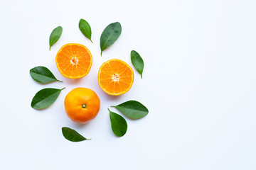 Fresh orange citrus fruit with green leaves on white.