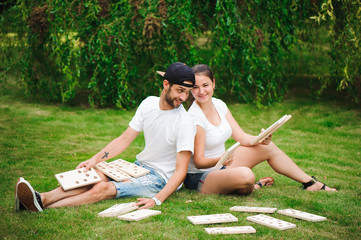 Young man and woman playing giant dominoes in the Park on the grass.