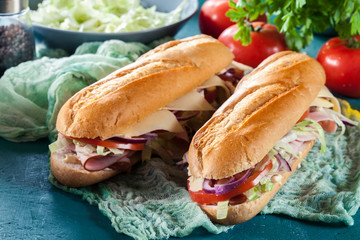 Submarine sandwiches with ham, cheese and vegetables
