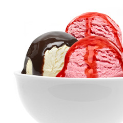 Vanilla and strawberry ice cream scoops with chocolate syrup, sauce or sherbet in bowl isolated on white background