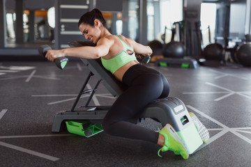 Sportswoman with dumbbells lying on bench