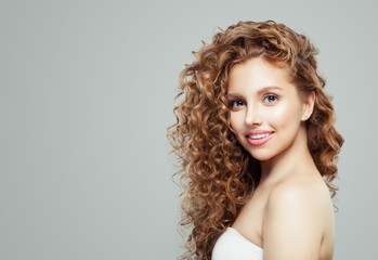 Happy woman with long healthy curly hair and clear skin. Facial expression, emotion