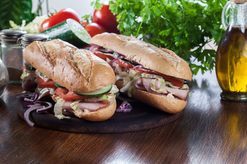 Submarine sandwiches with ham, cheese and vegetables