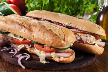 Submarine sandwiches with ham, cheese and vegetables