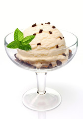 Vanilla ice cream scoop with chocolate chips in glass bowl isolated on white background