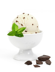Vanilla ice cream scoop with chocolate parts and mint in bowl isolated on white background